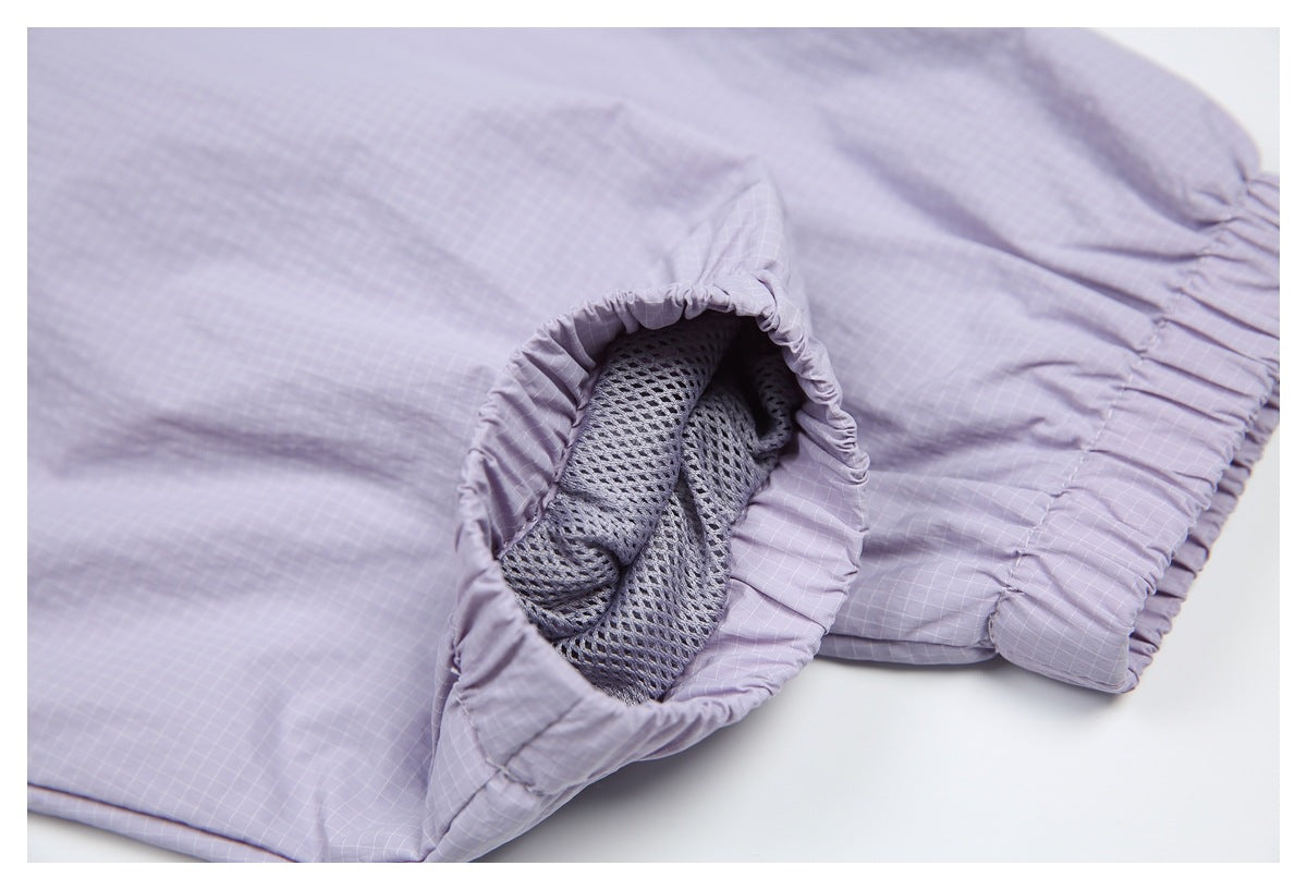 Close-up of an elasticized opening on a lavender grid-patterned garment, revealing gray mesh lining.