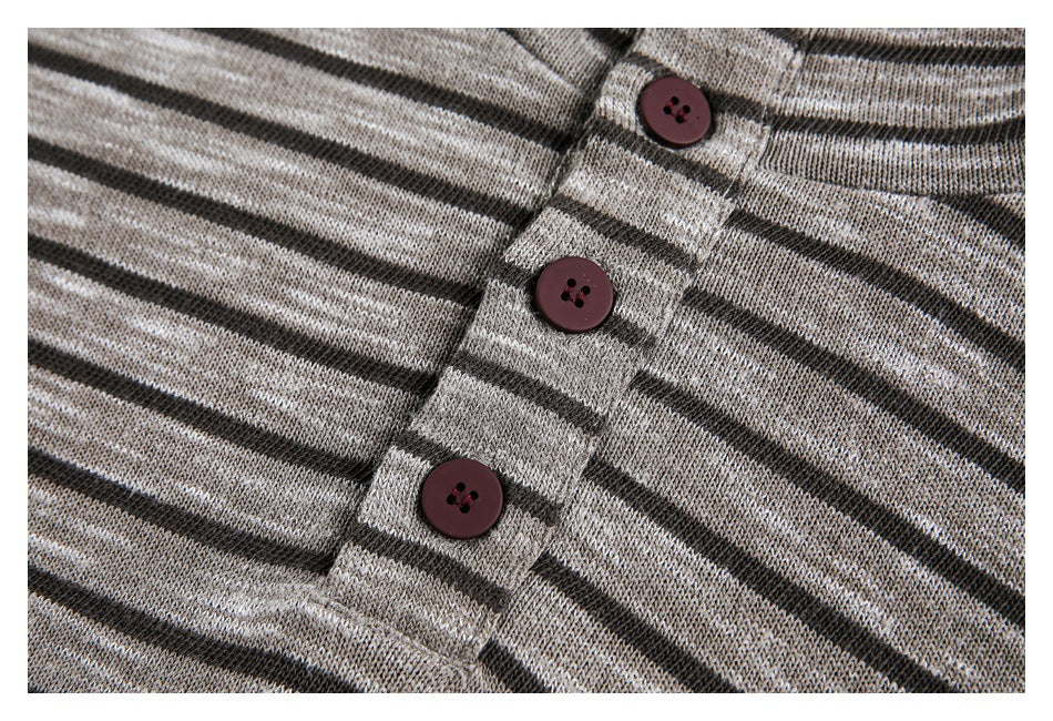 Close-up of three burgundy buttons on the placket of a gray and black striped knit garment.