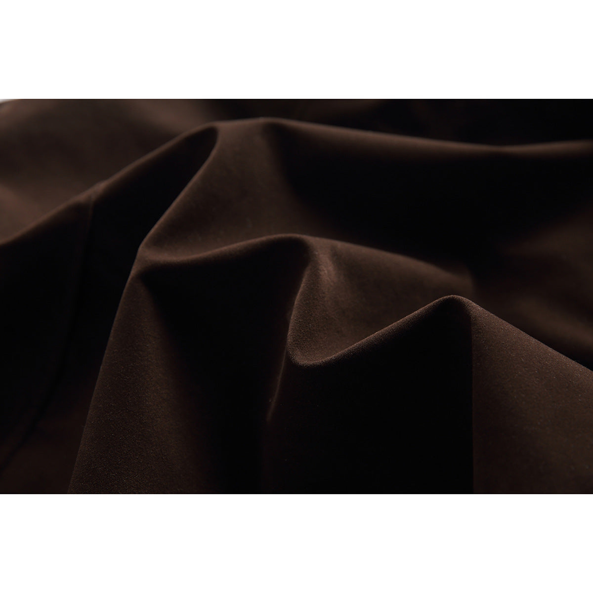 Very close view of dark brown jacket fabric arranged in soft folds.
