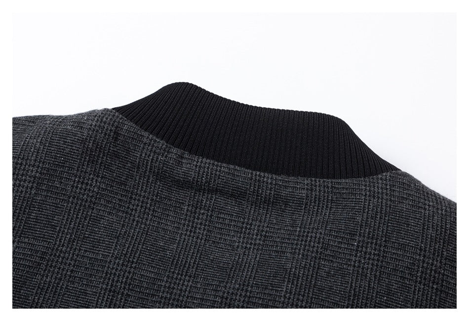 Close-up of the black ribbed collar and charcoal plaid upper back of a jacket.
