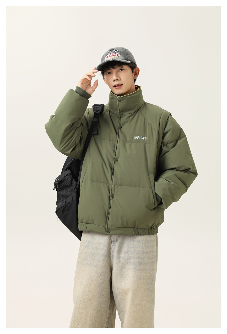 Model wearing an olive-green padded jacket with a high snap-button collar and elastic hem.