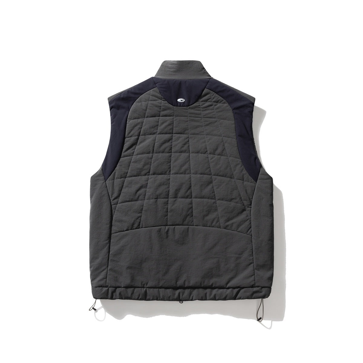 Back of a charcoal quilted vest with dark navy shoulder panels, a raised collar, and adjustable hem cords.