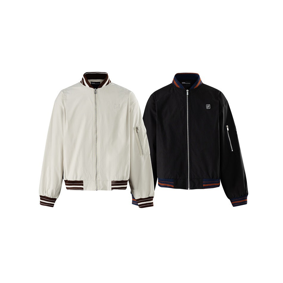 Two zip-front jackets shown from the front: light beige with brown and cream trim, and black with blue and orange trim.