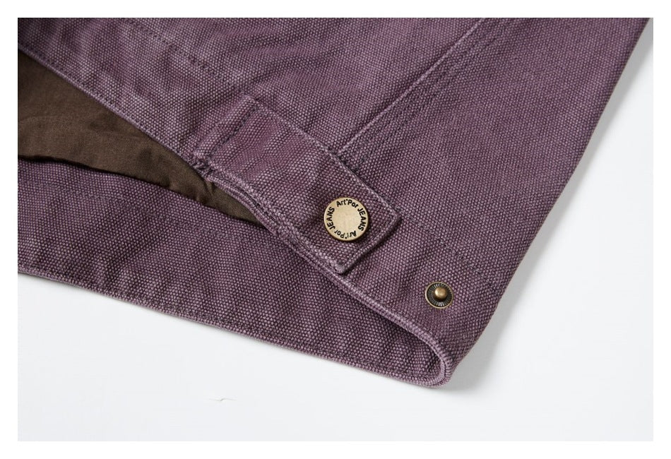 Close-up of the jacket's plum-colored hem with a branded button tab and metal snap.