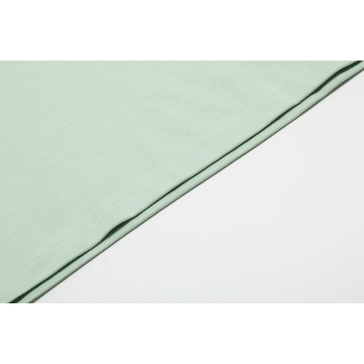 Close-up of the mint green T-shirt's double-stitched hem.