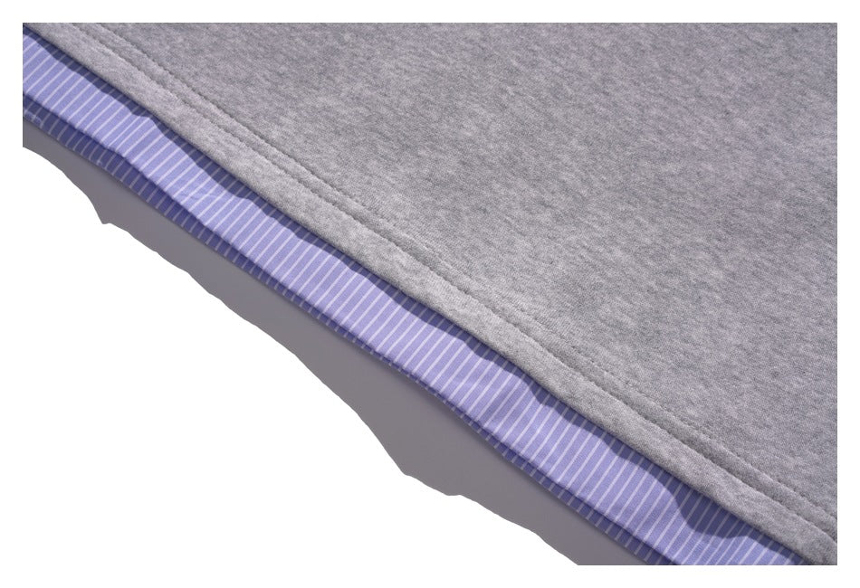 Close-up of the gray top's hem with lavender and white striped fabric showing underneath.