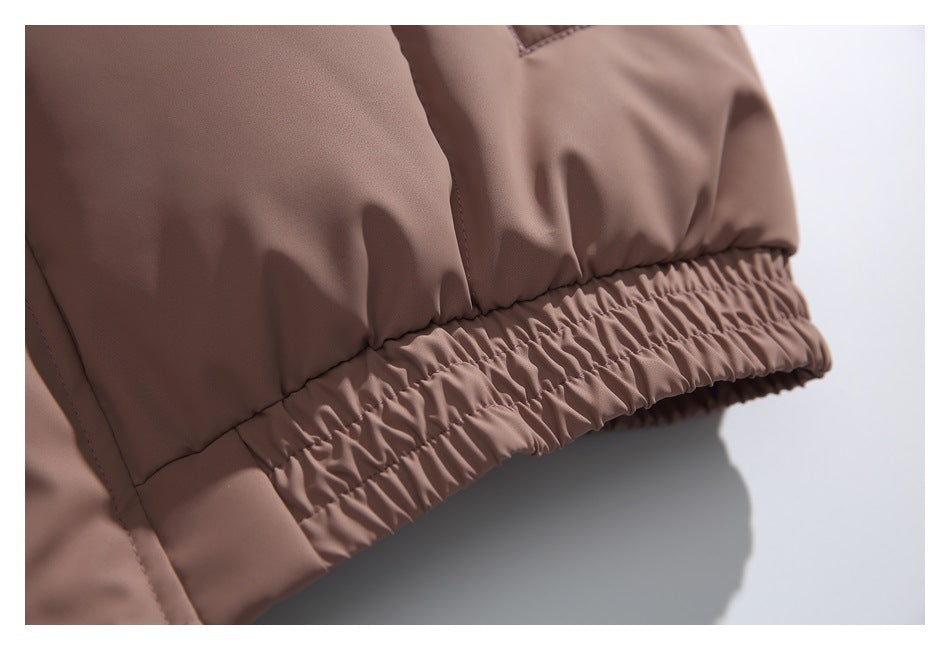 Close-up of the taupe-brown jacket's gathered elastic hem and stitching.