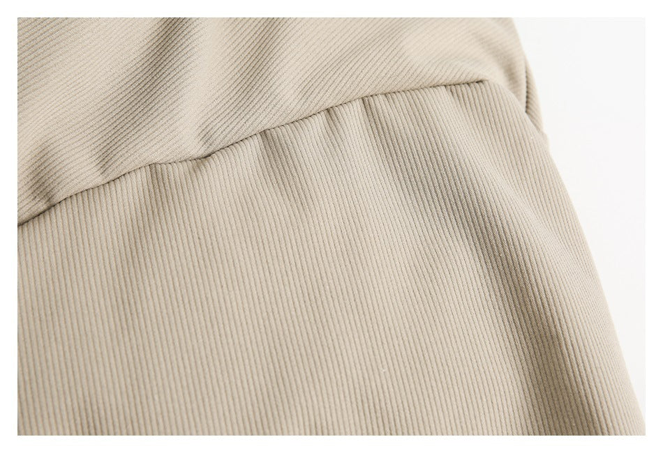 Close-up showing a seam and fine vertical ribbing on light taupe fabric.