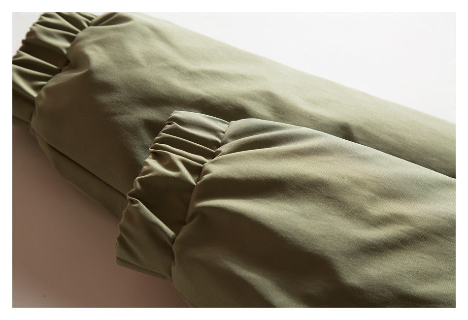 Close-up of an olive-khaki garment sleeve ending in a gathered cuff.