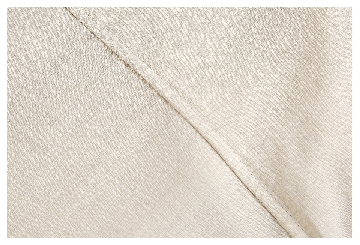 Close-up of a diagonal stitched seam on beige garment fabric.