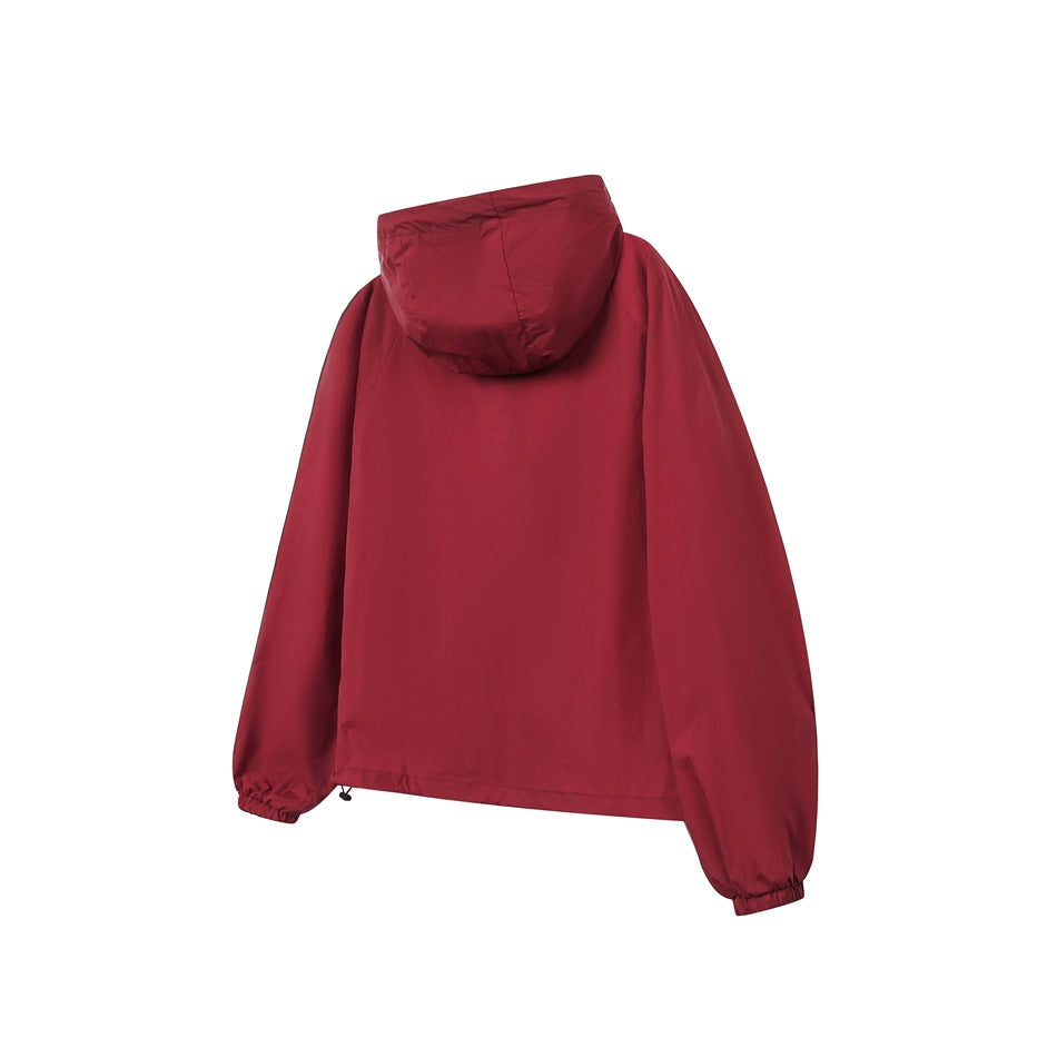 Back view of a burgundy hooded jacket with long sleeves and elastic cuffs.