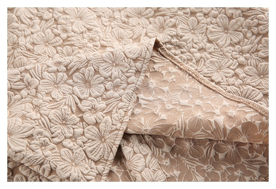 Close-up showing the reverse side and finished seam of beige floral fabric.