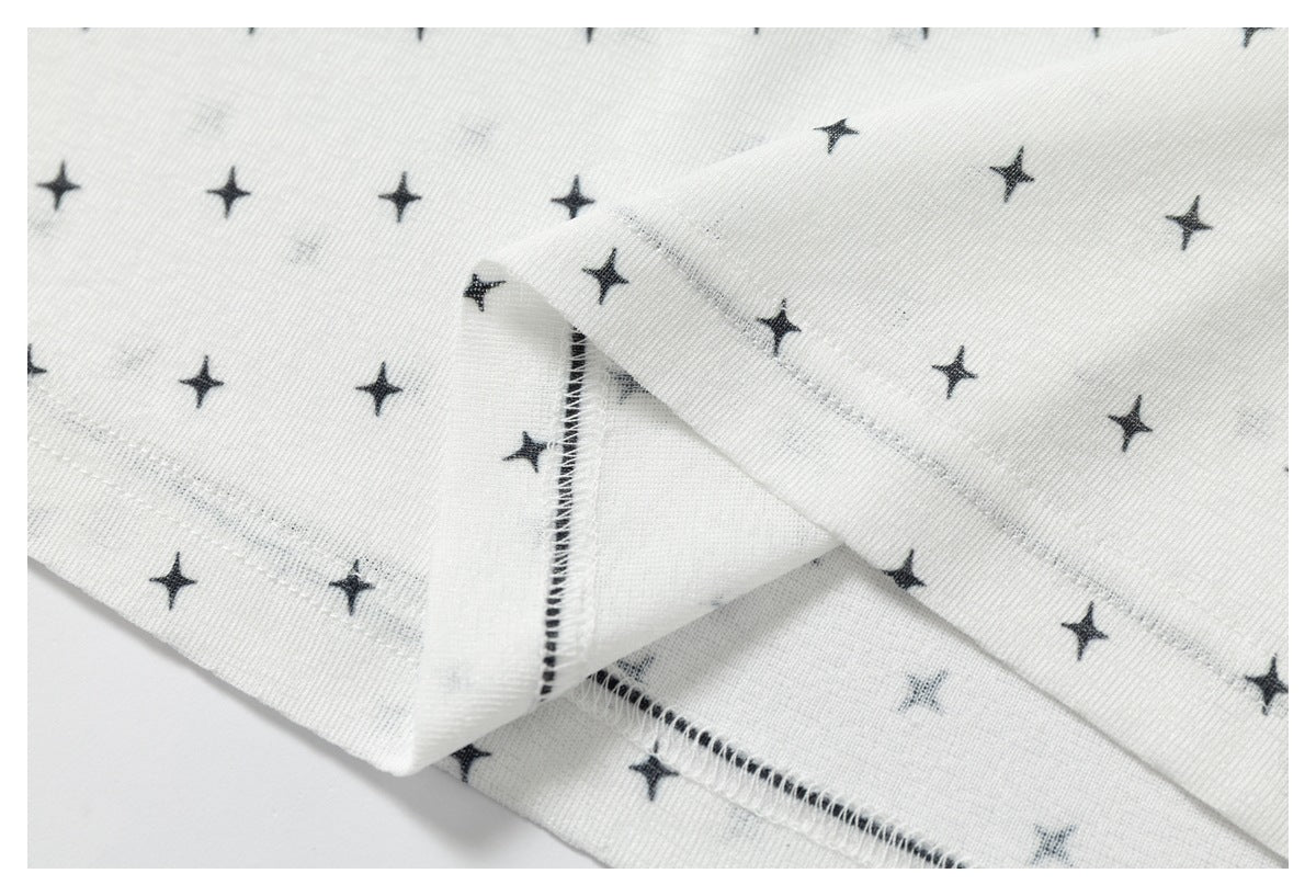 Close-up of the inside seam and folded hem of white fabric with a black star print.