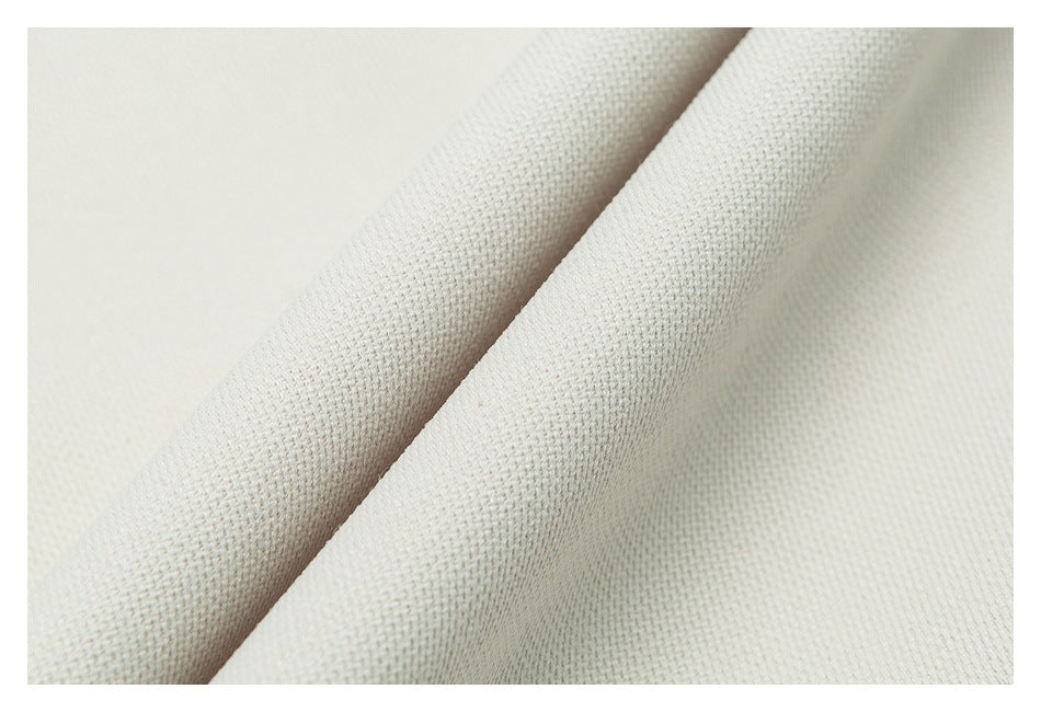 Close-up showing the textured surface of off-white garment fabric.