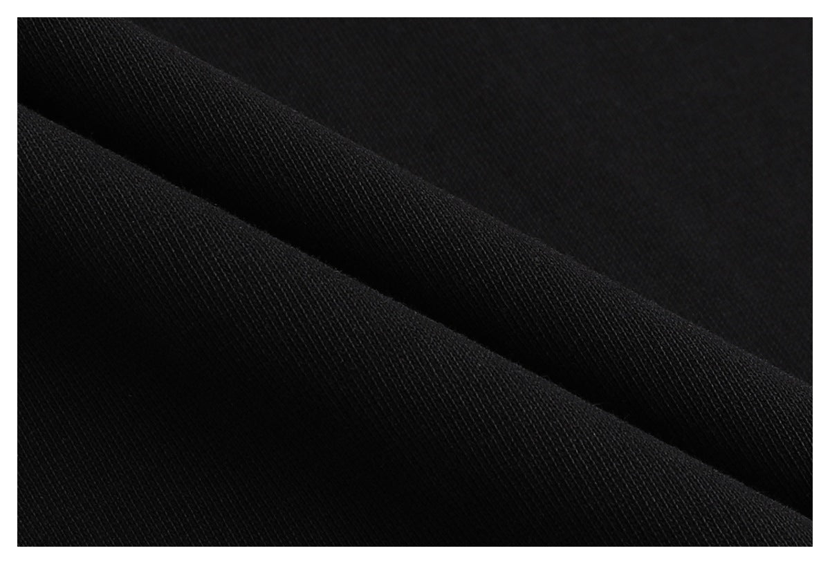 Extreme close-up of black fabric folded to show its fine knit texture.