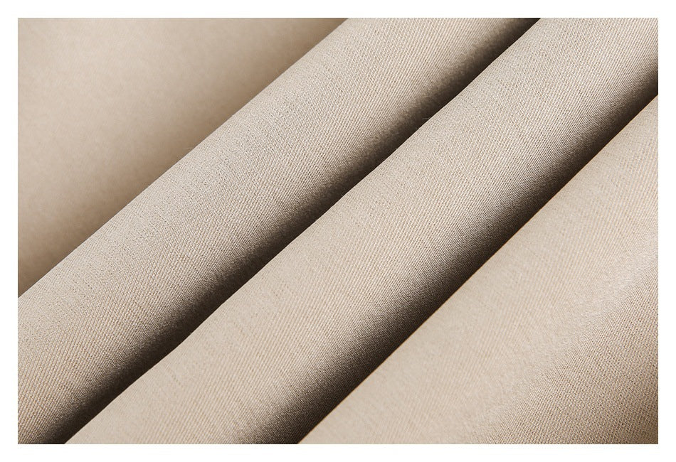 Macro view of the beige garment fabric draped in folds.