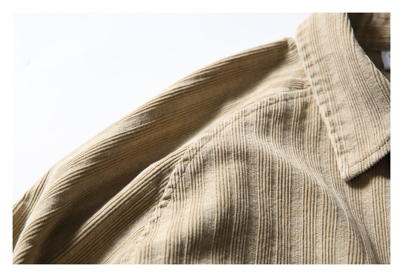 Close-up of the tan shirt's textured shoulder seam and pointed collar edge.