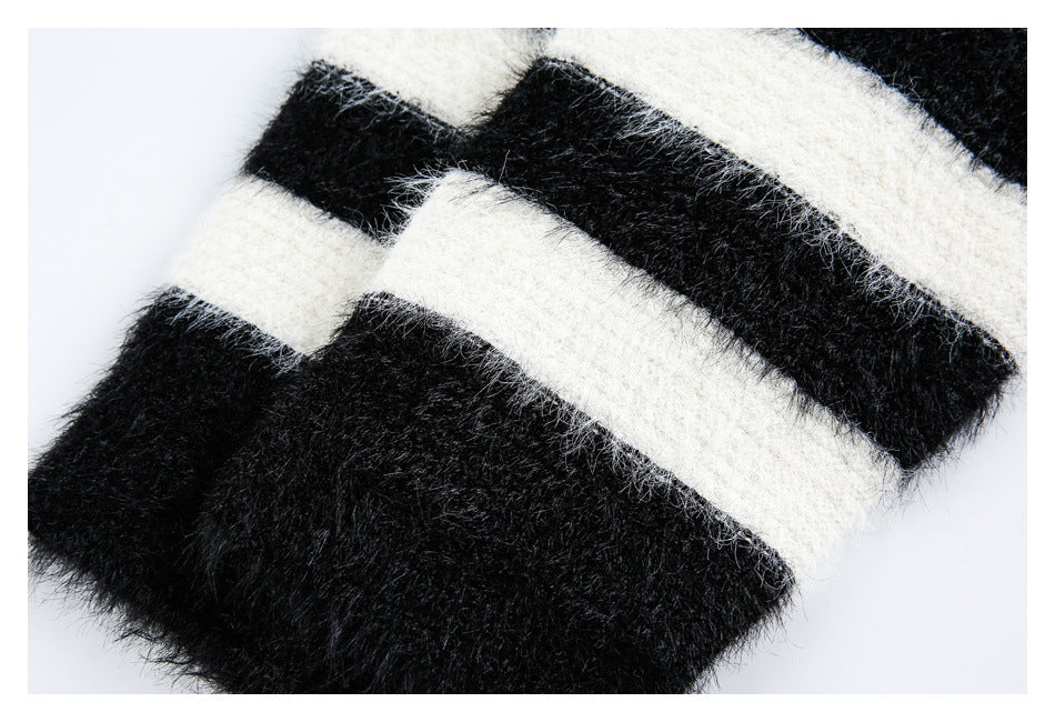 Close-up of fuzzy black-and-ivory stripes on knit fabric, with part of a folded edge visible.