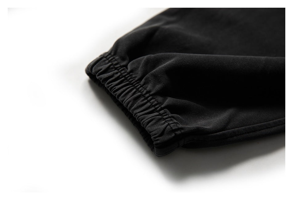 Close-up of the gathered elastic ankle cuff on black jogger pants.