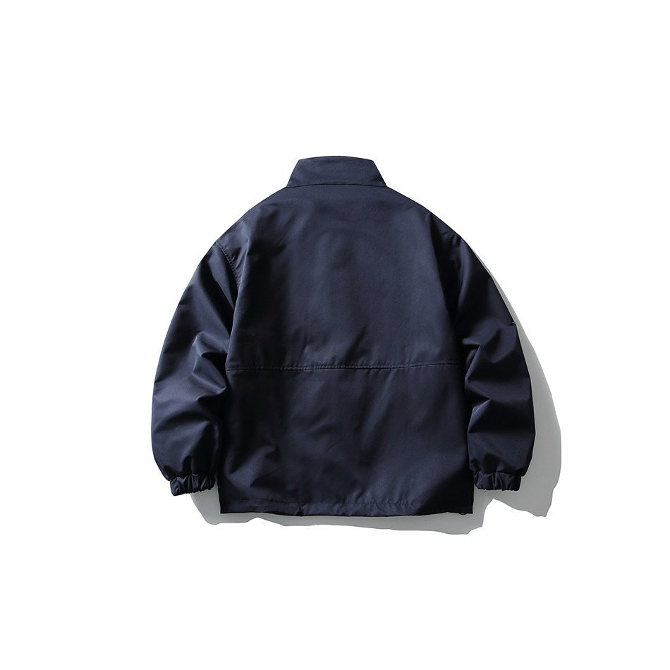 Navy stand-collar jacket flat lay, back view, with horizontal back seam and elastic cuffs