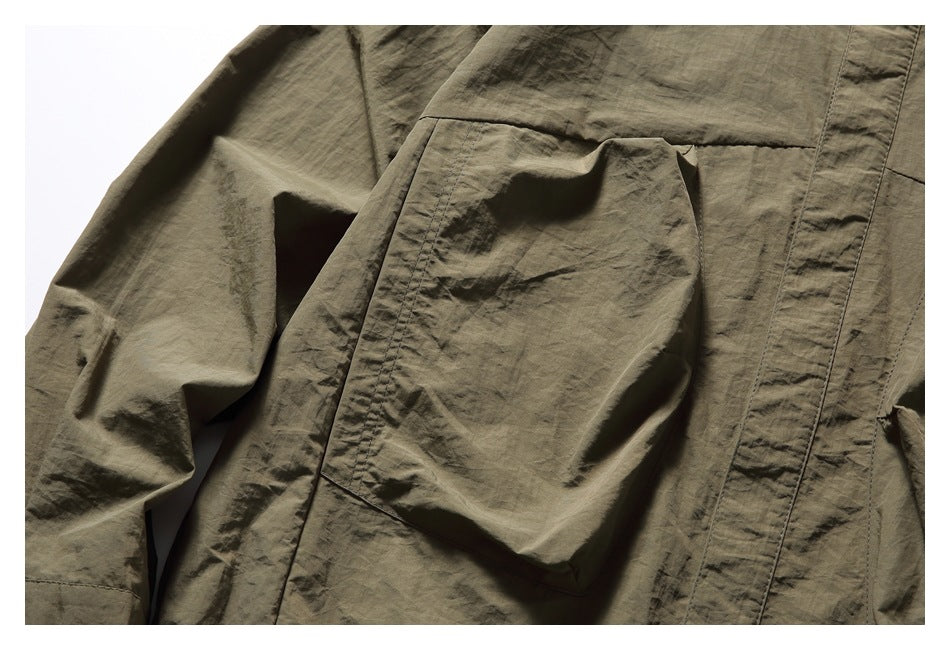 Close-up of a large patch pocket and seam stitching on the olive-brown shirt.