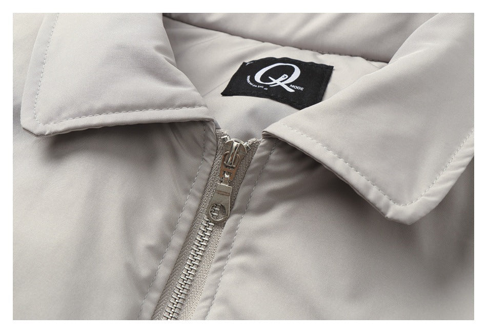 Close-up of a light gray jacket collar, front zipper, and sewn-in black label.