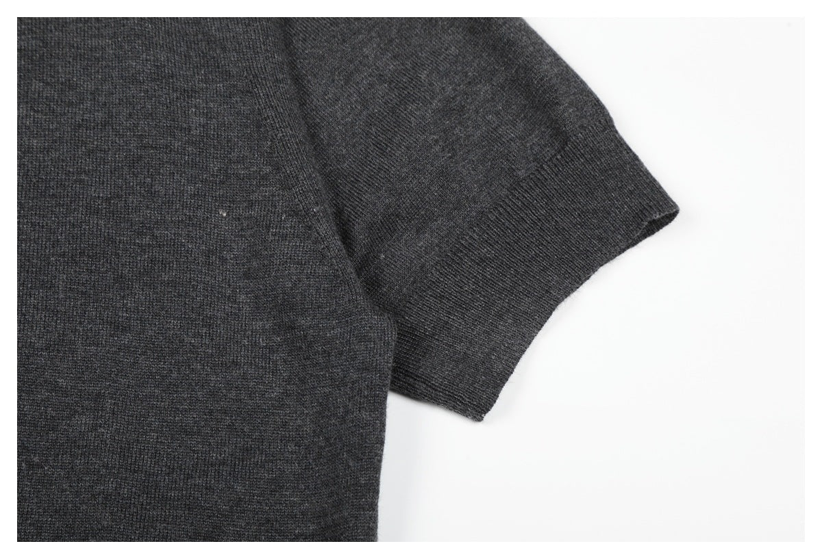 Close-up of a charcoal knit top's short sleeve and ribbed cuff.