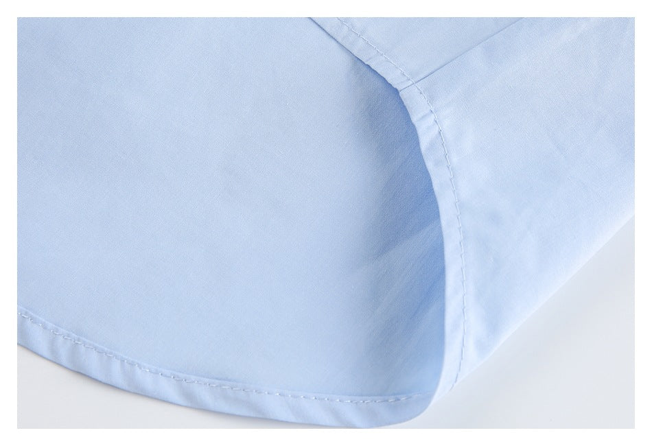 Close-up of a pale blue garment hem with curved stitching and a side seam.