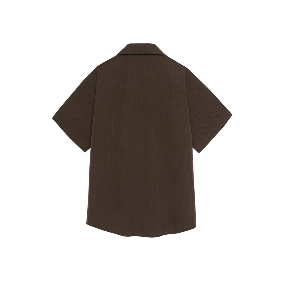 Back view of a plain brown short-sleeve shirt with textured stripes, yoke seam and curved hem