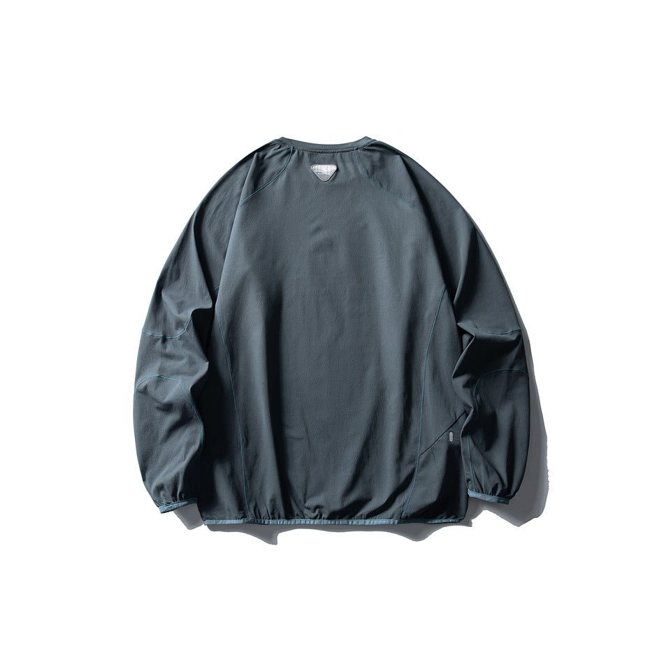 Back view of a slate blue-gray pullover with long raglan sleeves and subtle teal piping.