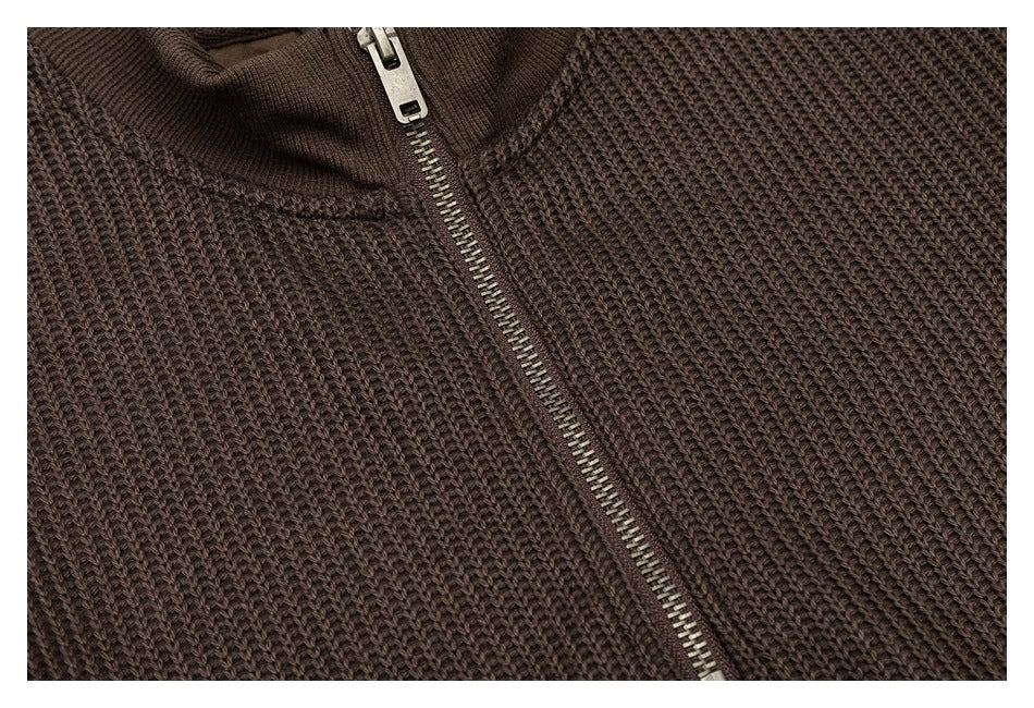 Close-up of the dark brown sweater's chunky knit texture and metal front zipper.