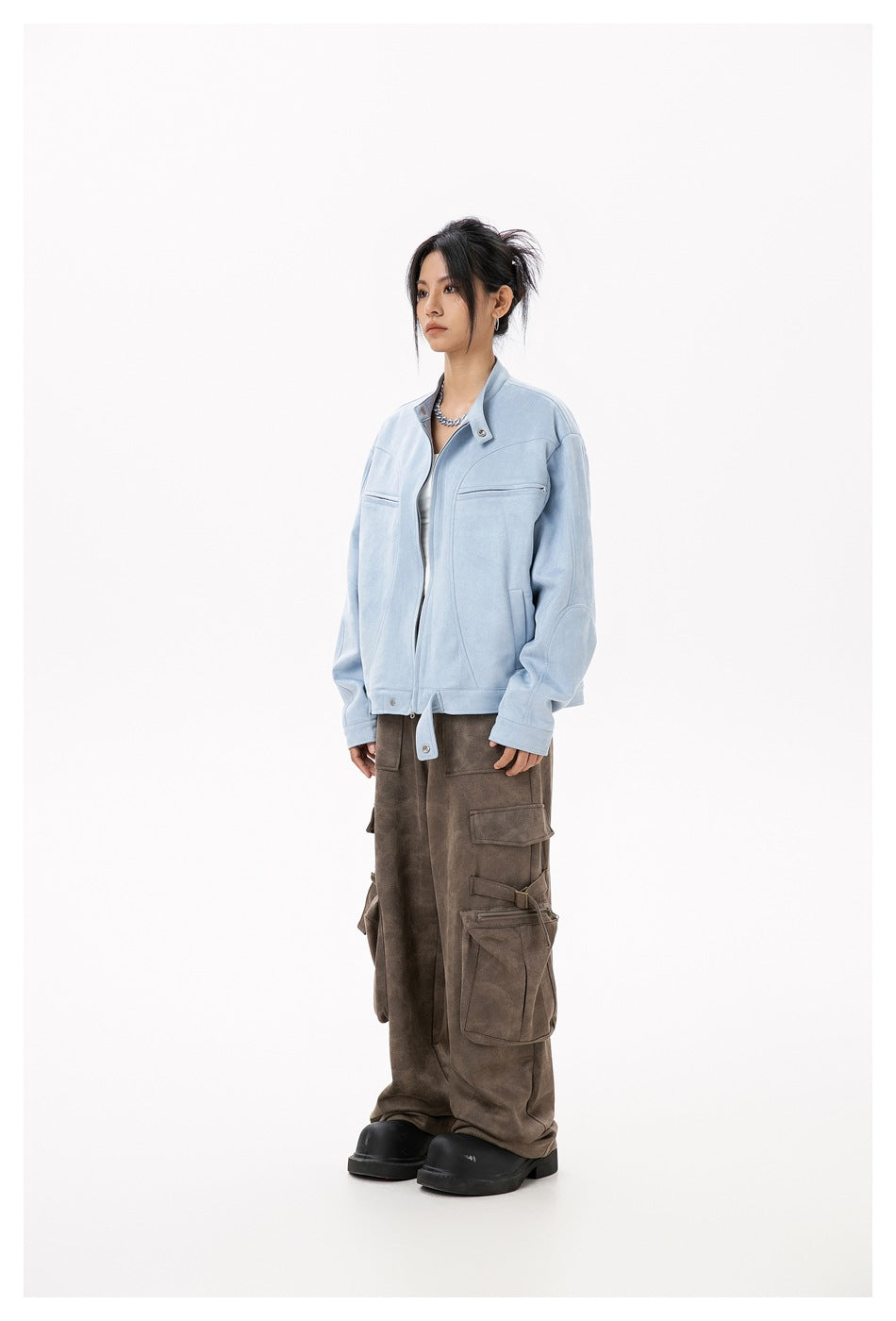 Model in a light blue stand-collar zip jacket with brown cargo pants, angled side view