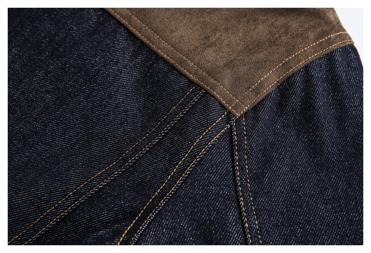 Close-up of a dark indigo denim jacket seam beneath a brown shoulder panel, with contrasting tan stitching.