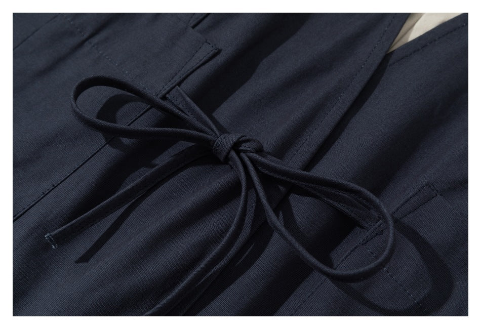 Close-up of a dark navy garment with a matching cord tied in a bow.