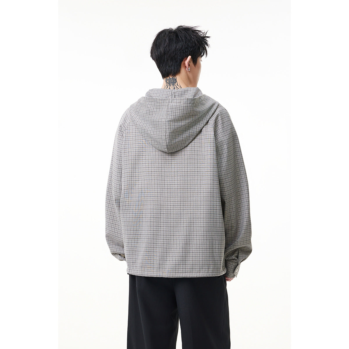 Back view of a model wearing a gray micro-check hooded pullover and black trousers.