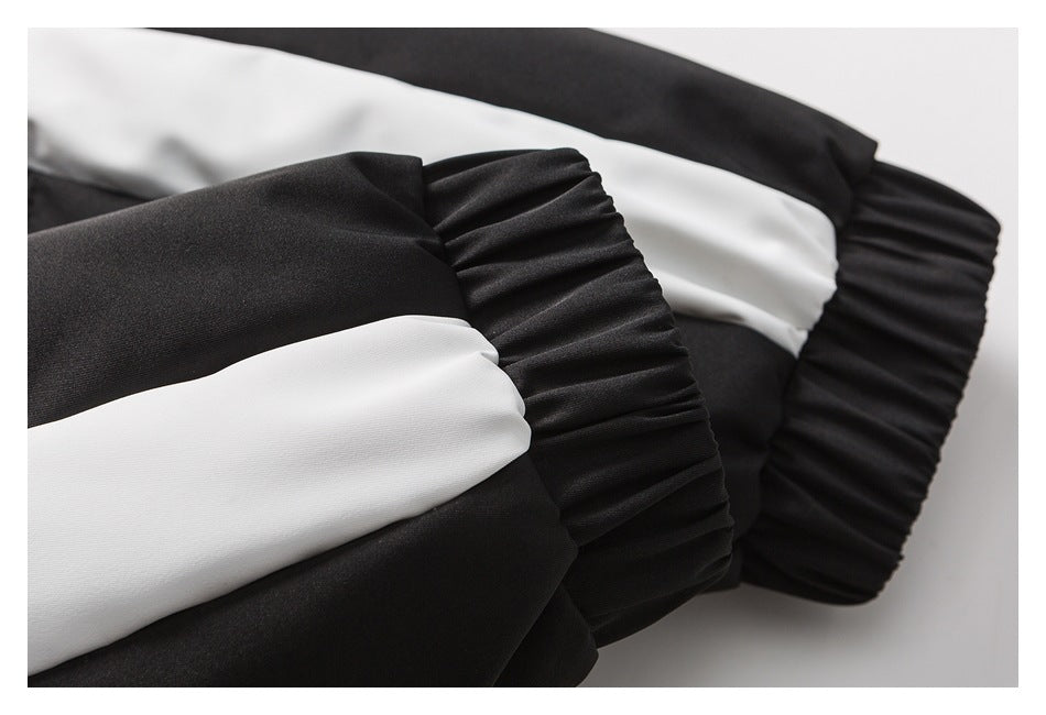 Close-up of a gathered black cuff and a wide white stripe on the garment sleeve.