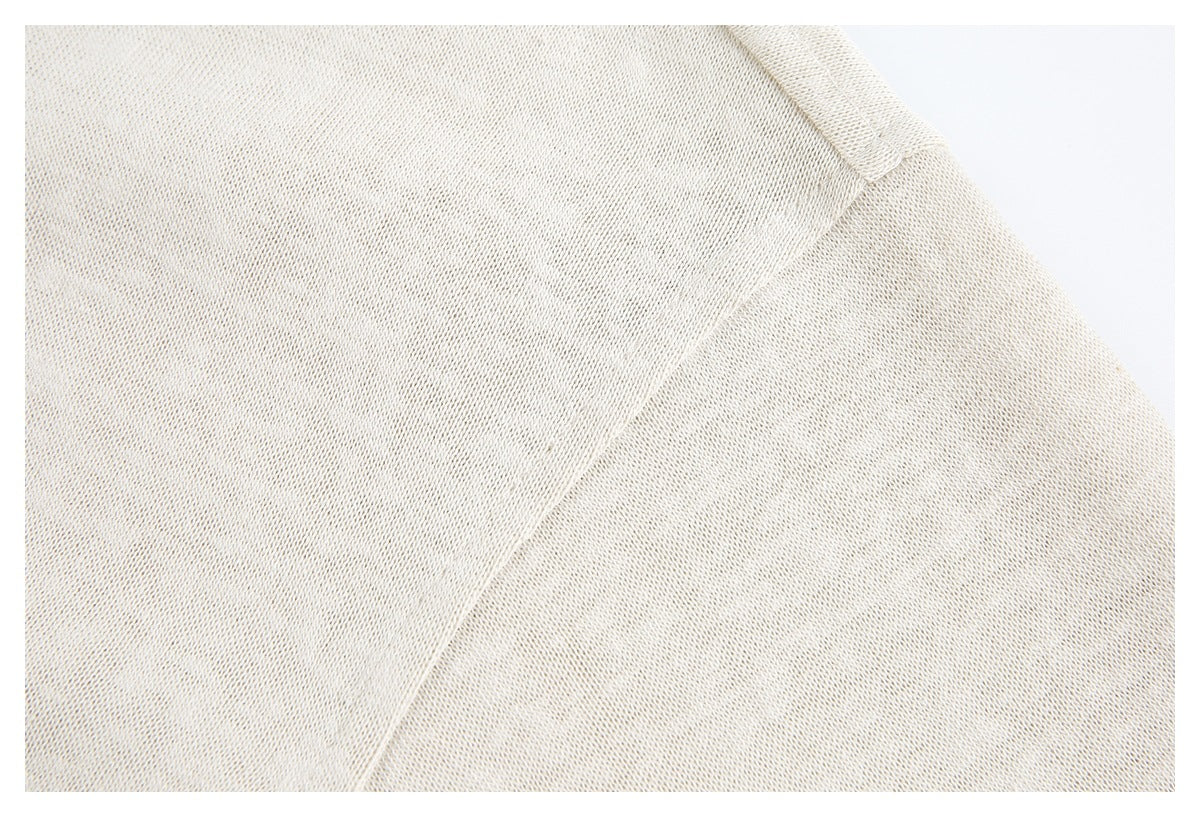 Close-up of cream knit fabric and a diagonal shoulder seam.