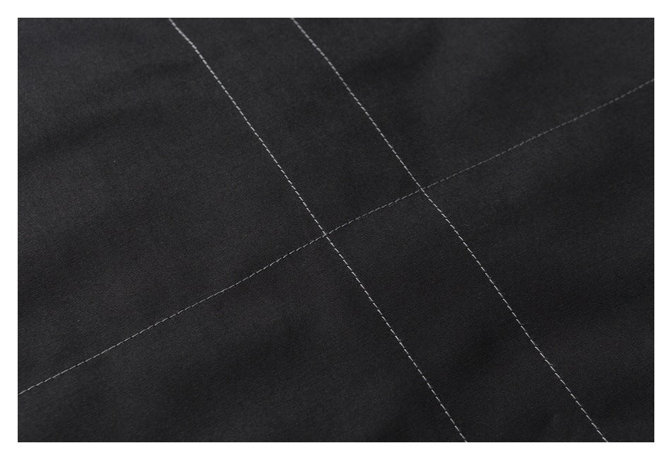 Close-up of black fabric with intersecting rows of light contrast stitching.