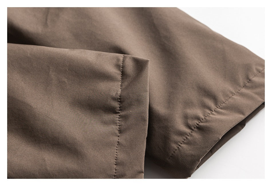 Close-up of a dark brown garment sleeve cuff and stitched hem.