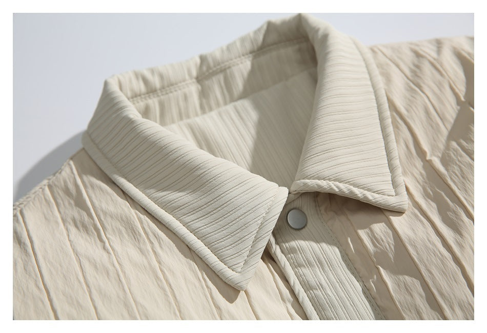Close-up of the ivory jacket's ribbed pointed collar and upper snap-button placket.