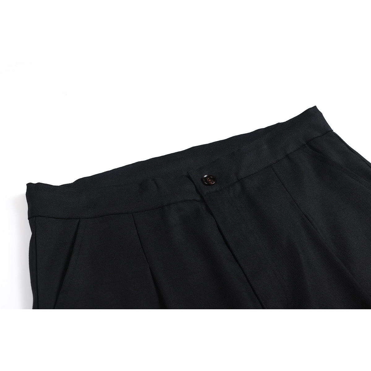 Close-up of black trousers showing the waistband, button, fly, and front pleats.