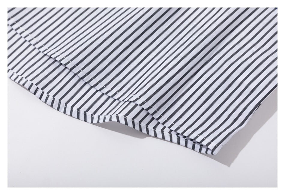 Close-up of the curved hem and seam of a white shirt with narrow black stripes.