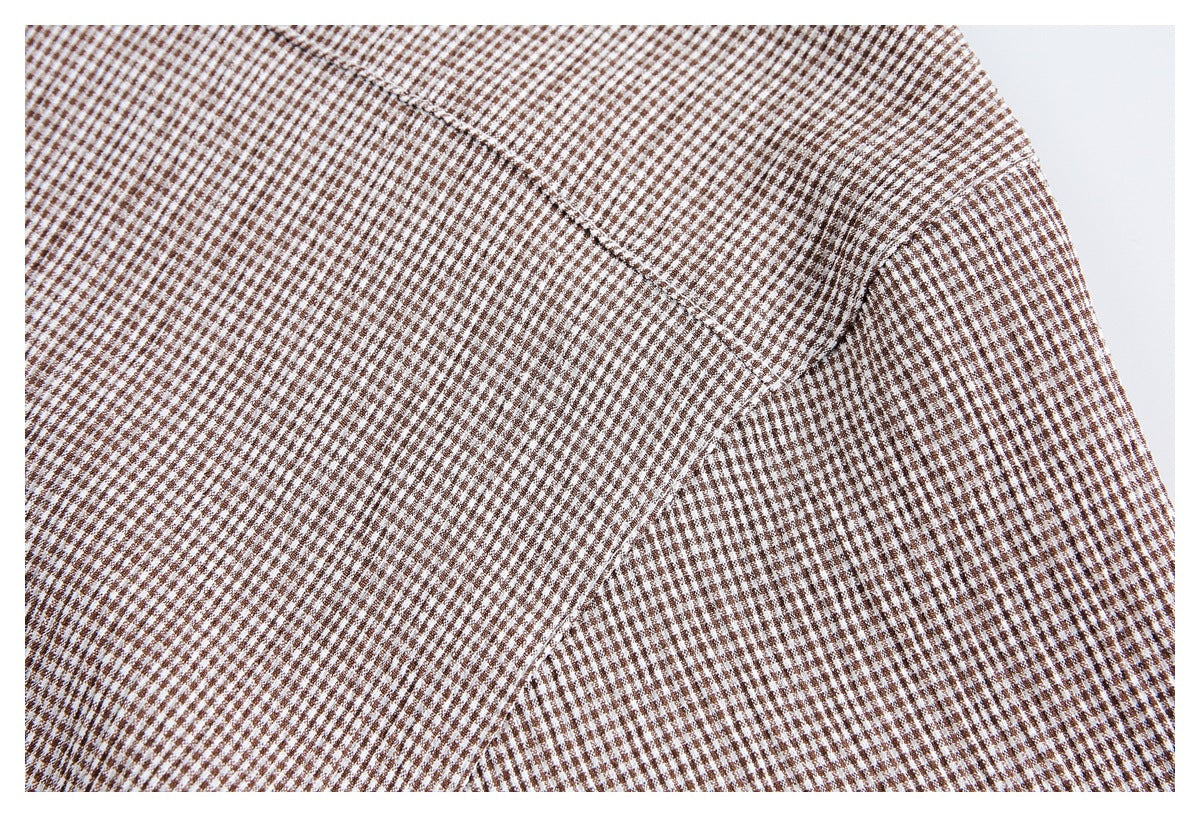 Close-up of intersecting seams on brown-and-white small-check fabric.