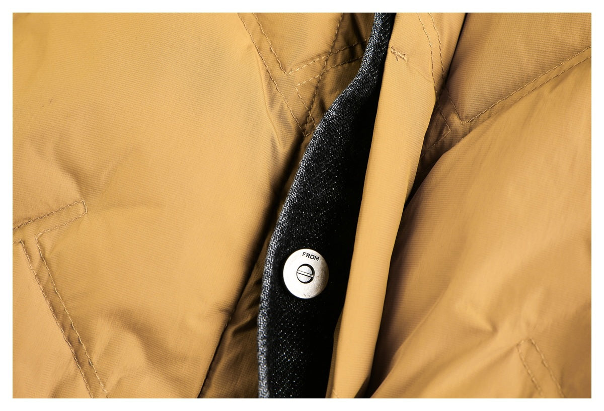 Close-up of a mustard garment's dark contrasting placket trim and metal button.