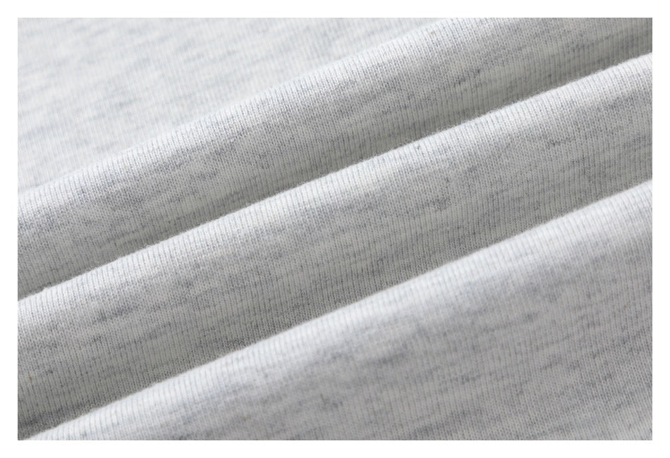 Close-up of folded light gray heather fabric showing its knit texture.