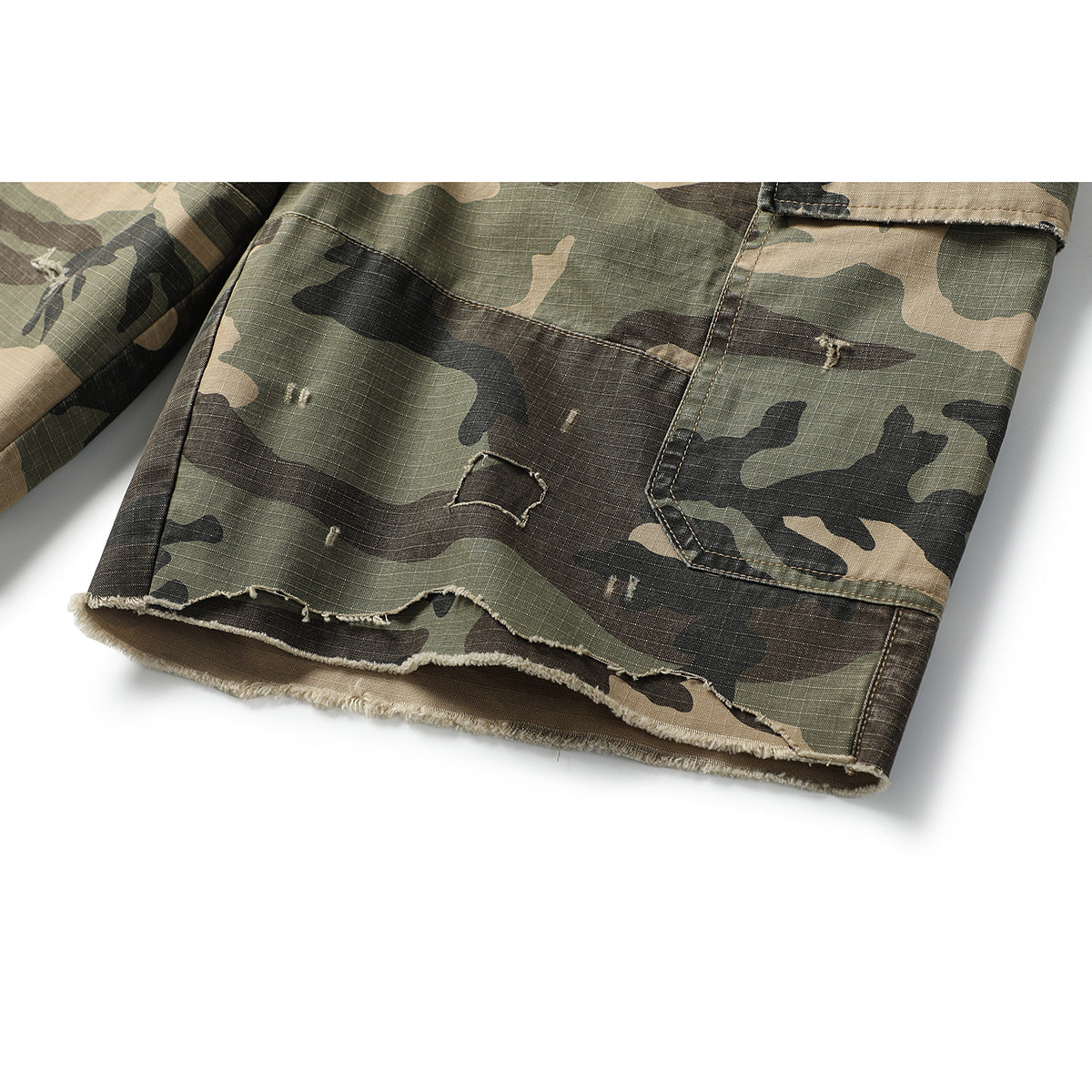 Close-up of camouflage shorts showing a cargo pocket and distressed, frayed hem.