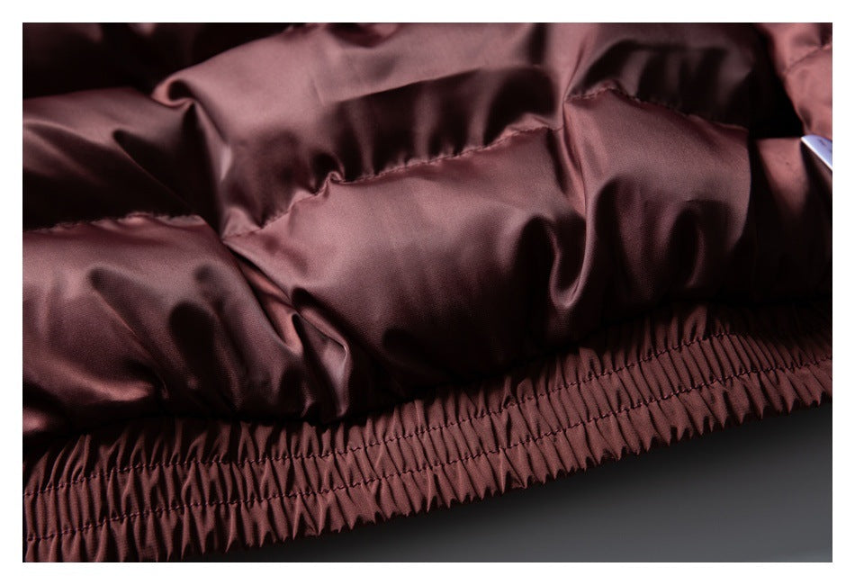 Close-up of a burgundy garment with a gathered elastic hem and stitched seams.