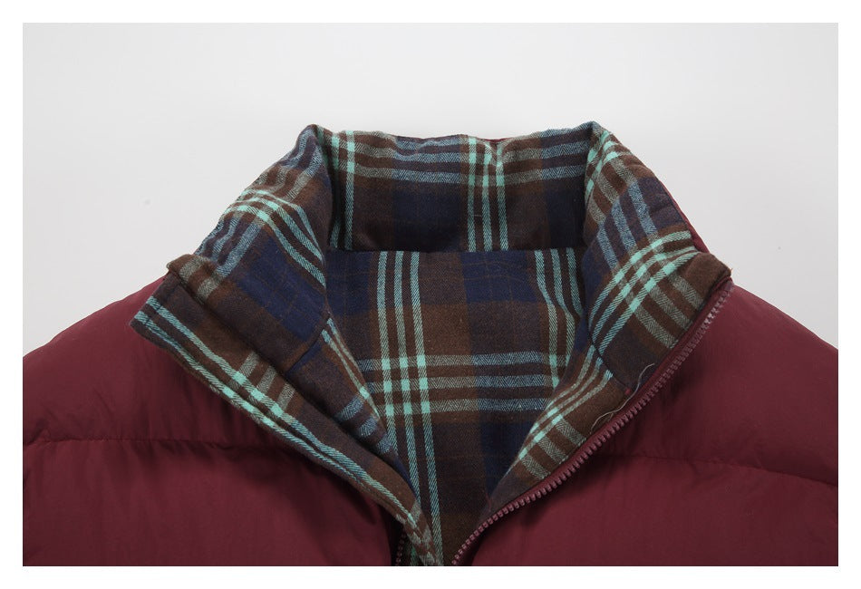 Close-up of a burgundy jacket with a wide brown, navy, and teal plaid-lined collar and front zipper.