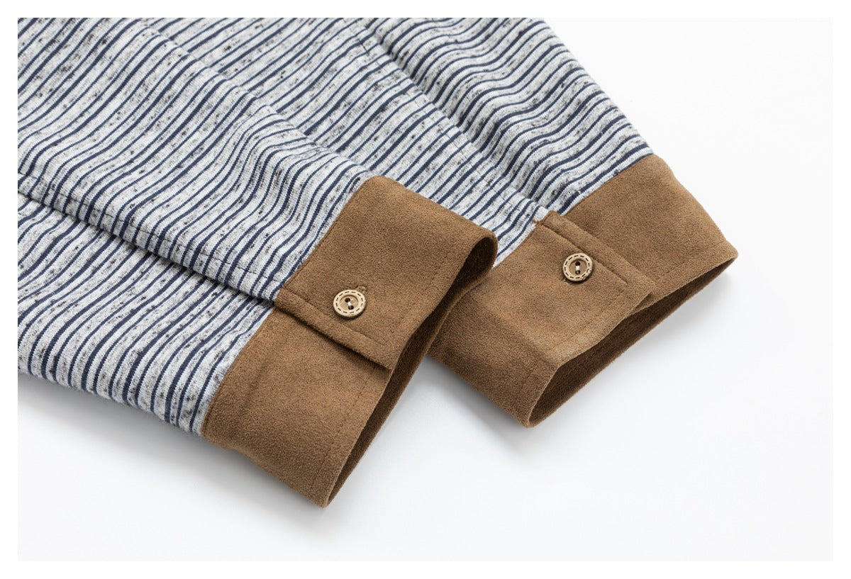 Close-up of a gray and navy striped garment with wide brown cuffs and decorative buttons.