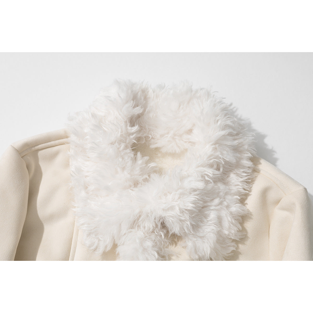 Close-up of a cream coat with a voluminous white curly-fur collar.